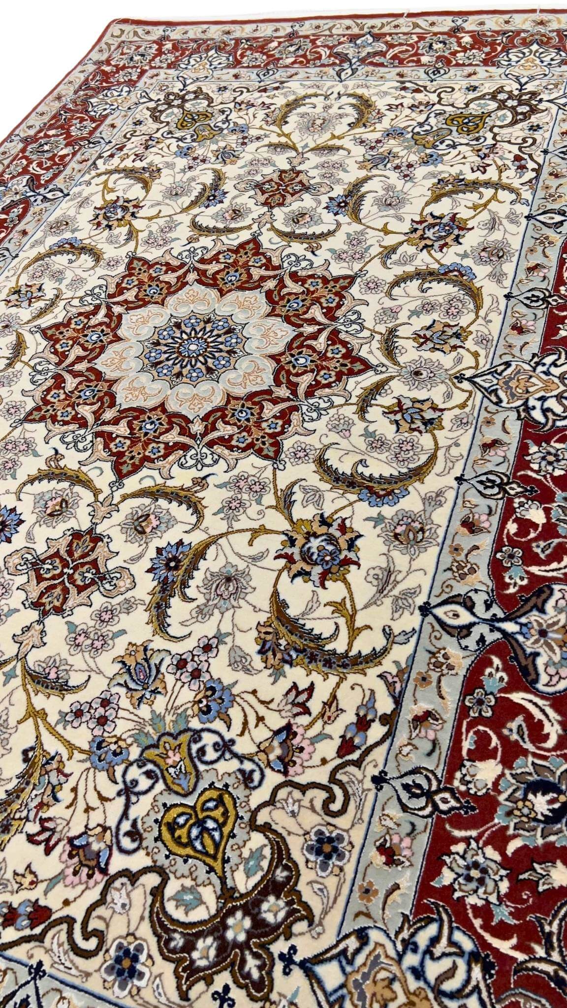 "Close-up of a Persian Isfahan rug with intricate red and ivory floral patterns."